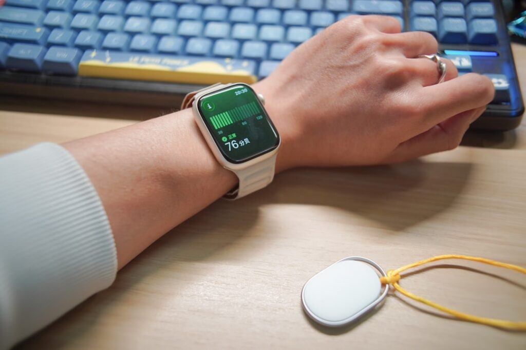 Person wearing a smartwatch with a keyboard in-ear monitor.