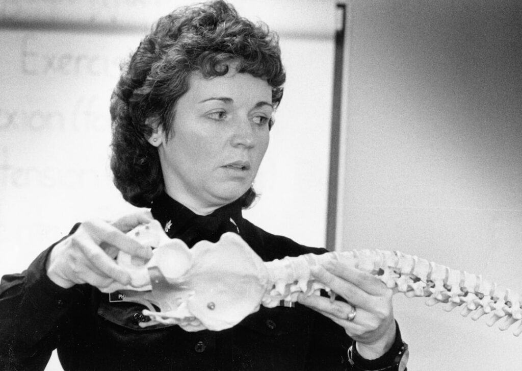Woman holding a human spine model